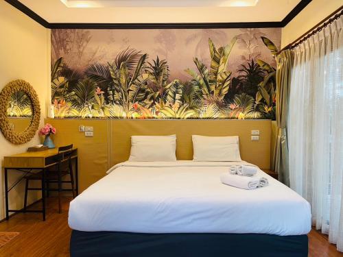 a bedroom with a large bed with a painting on the wall at สงขลาคีรี รีสอร์ท SongkhlaKeeree Resort in Ban Khao Rup Chang