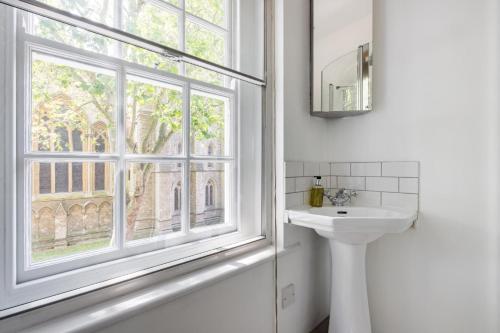 a bathroom with a sink and a window at London Is Yours - 2 Bedroom in Kensington in London