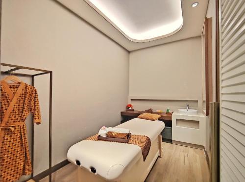 a small room with two beds and a sink at Swiss-Belhotel Solo in Solo