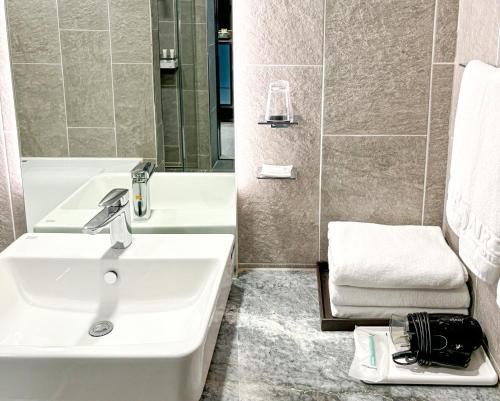 a bathroom with a sink and a bath tub at Airsky Hotel Incheon in Incheon