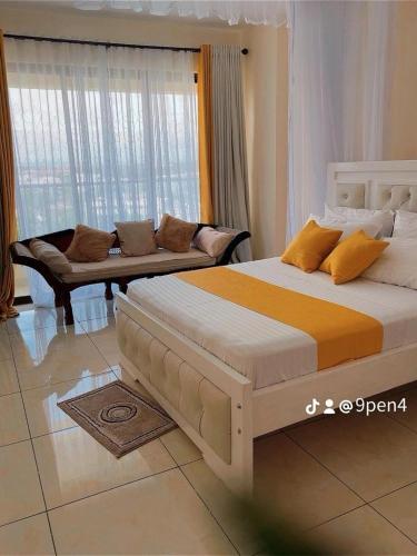 a bedroom with a large bed and a couch at 3RD Ave. Beach Apartment Nyali, Mombasa, North Coast in Nyali