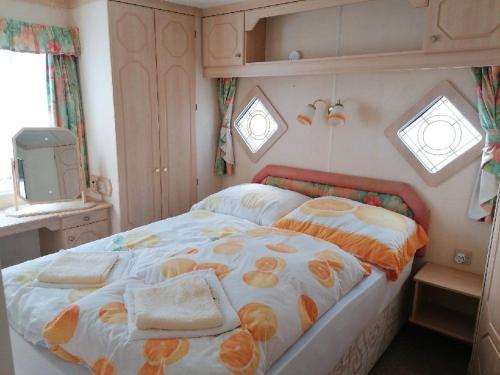 una camera da letto con un letto e asciugamani di Hídláb Mobil Apartman a Kimle