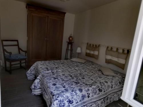 een slaapkamer met een groot bed en een stoel bij Gîte Huisseau-sur-Cosson, 3 pièces, 4 personnes - FR-1-491-287 in Huisseau-sur-Cosson