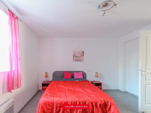 ein Schlafzimmer mit einem roten Bett mit rosa Kissen in der Unterkunft Appartement Châtelaillon-Plage, 2 pièces, 4 personnes - FR-1-535-17 in Châtelaillon-Plage