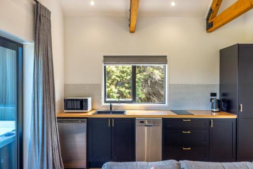 cocina con fregadero y ventana en The Guest House at Te Whau Retreat en Omiha