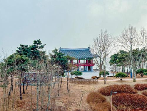 a chinese building in a park with trees at Airsky Hotel Incheon in Incheon