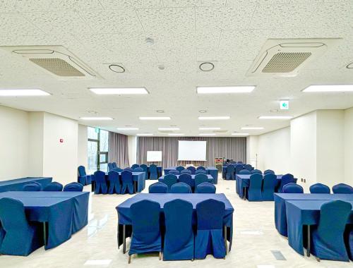 une grande chambre avec des tables et des chaises bleues dans l'établissement Airsky Hotel Incheon, à Incheon