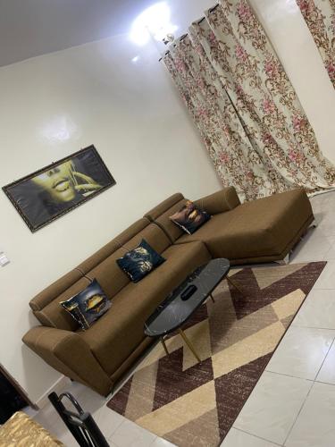 a living room with a brown couch in a room at Appartement spacieux a ngor et a proximité des almadies in Ngor