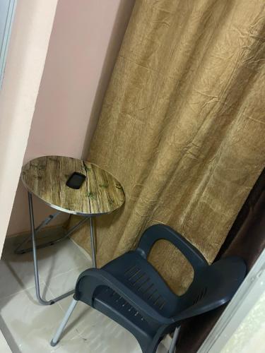 a chair and a table in front of a curtain at Appartement spacieux a ngor et a proximité des almadies in Ngor