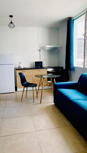 a living room with a blue couch and a table at Little urban idéal pour les séjours de moyenne durée proche de tout in Pointe-à-Pitre