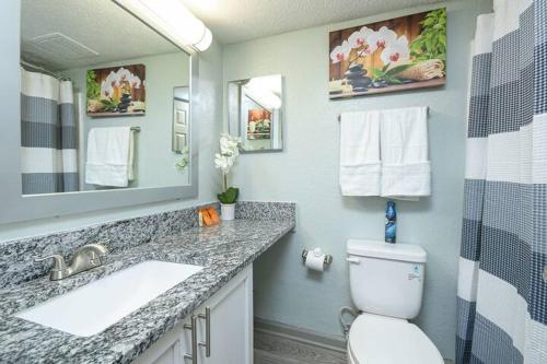 a bathroom with a sink and a toilet and a mirror at 2BD/2BA - Walk to *The Battery ATL* w/Free Parking in Atlanta