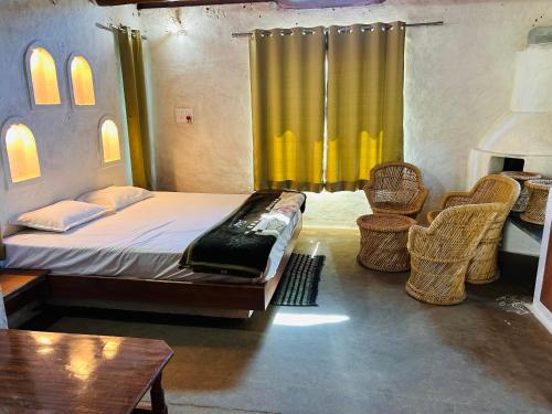 een slaapkamer met een bed met rieten stoelen en een raam bij Girija Homestay in Shamsgarh