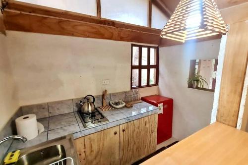 a kitchen with a stove and a red refrigerator at Espacio Borde Rio, Casa Pisqu in Vicuña