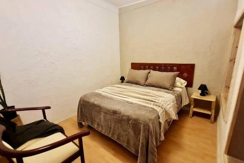um quarto com uma cama e uma cadeira em Espacio Borde Rio, Casa Pisqu em Vicuña