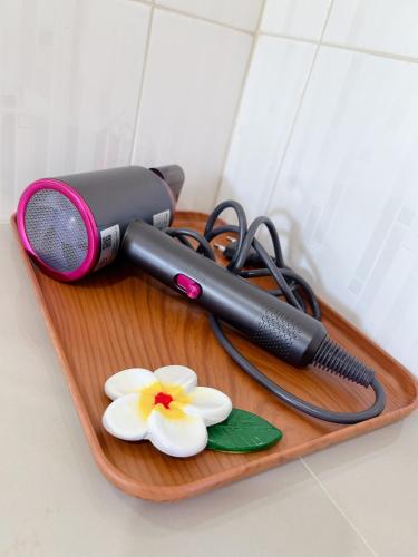 a hair dryer and flowers on a cutting board at FairHouse khaolak in Khao Lak