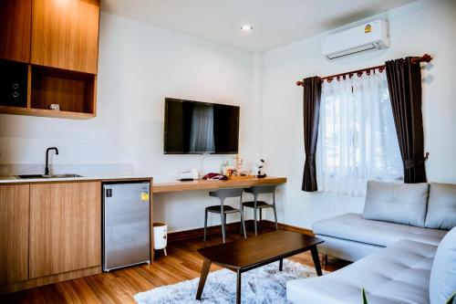 uma cozinha e uma sala de estar com um sofá e uma mesa em Nainan resotel ในน่าน รีโซเทล em Nan