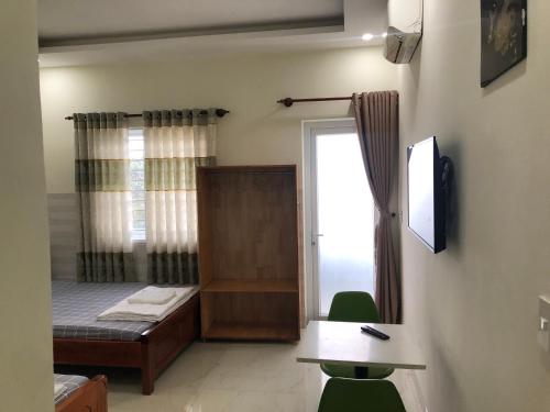 a room with a bed and a desk and a window at Homestay 05 in Vung Tau