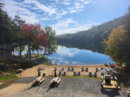 - une vue sur un lac avec un groupe de tables de pique-nique dans l'établissement Auberge Morritt, à Mont-Tremblant