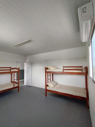 Cette chambre comprend 2 lits superposés et une fenêtre. dans l'établissement JM Alojamento, à Igarassu