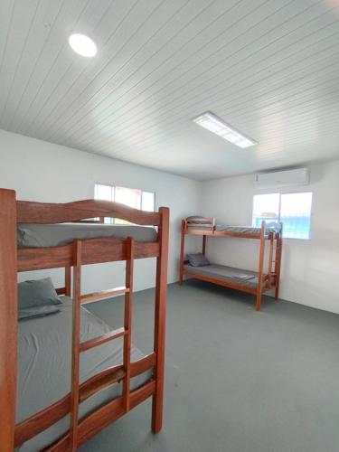 a room with two bunk beds and two windows at JM Alojamento in Igarassu