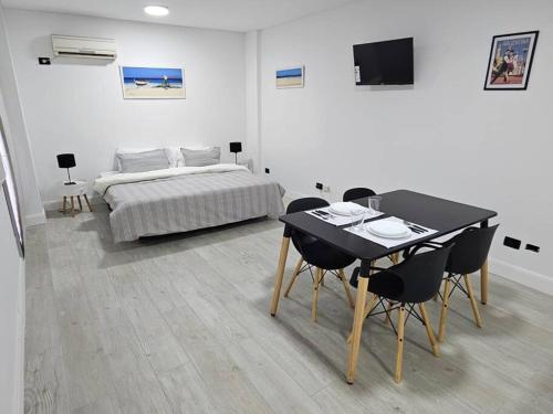 een slaapkamer met een bed en een tafel en stoelen bij Hermoso apartamento en el corazón de Palermo - Cerca de todo in Buenos Aires