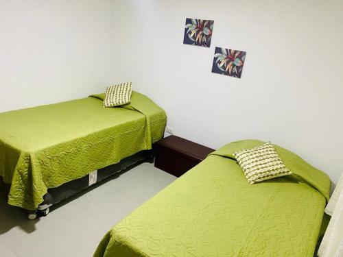 2 Betten nebeneinander in einem Zimmer in der Unterkunft Acogedora casa en Pisco a 20 min de paracas in Pisco