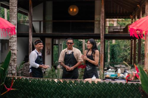 a group of three people standing in a kitchen at Surya Kembar Villas in Ubud