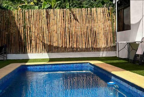 a swimming pool in front of a wooden fence at Departamento Amueblado con Alberca Pedregal C in Tamasopo