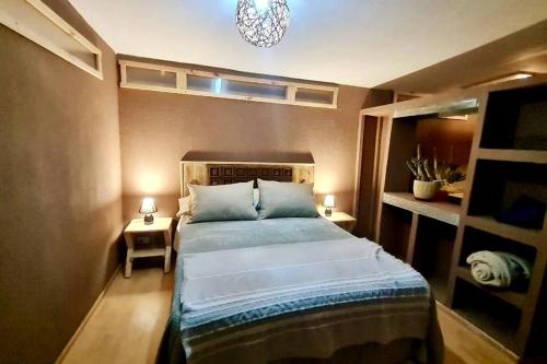 1 dormitorio con cama y lámpara de araña en Borde rio, Eco-Cabaña Jararankhu en Vicuña