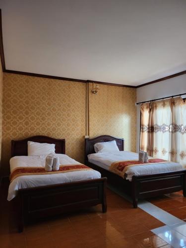 two beds in a hotel room with two at Vangvieng Sisavang Mountain View Hotel in Vang Vieng