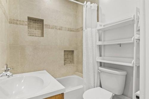 Łazienka z białą toaletą i umywalką w obiekcie Palm Wave Says - Designers Stay - No Extra Fees w mieście West Palm Beach