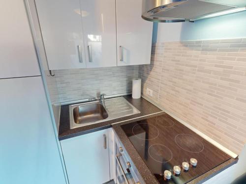 eine kleine Küche mit weißen Schränken und einem Waschbecken in der Unterkunft Studio Menton, 2 pièces, 4 personnes - FR-1-196-348 in Menton