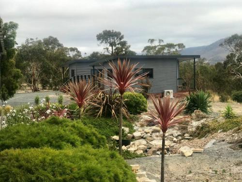 a garden in front of a house with plants at Derwent Mist Villas (Acacia Villa) in Bridgewater