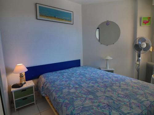 - une chambre avec un lit, une lampe et un miroir dans l'établissement Joli T2 cabine avec terrasse face mer, parking, ascenseur, pour 5 pers - FR-1-472A-297, à Sète