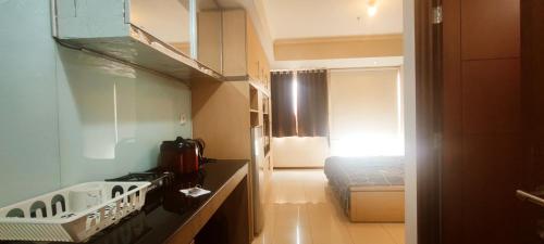 Convenient Apartments at West Jakarta في جاكرتا: غرفة صغيرة بها موقد وسرير