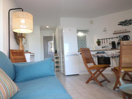 un salon avec un canapé bleu et une cuisine dans l'établissement Charmant T2 avec terrasse pour 4 pers, Sète – parking sécurisé, proche commodités - FR-1-472A-292, à Sète
