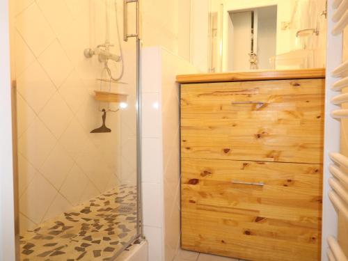 La salle de bains est pourvue d'une douche et d'une armoire en bois. dans l'établissement Charmant T2 avec terrasse pour 4 pers, Sète – parking sécurisé, proche commodités - FR-1-472A-292, à Sète