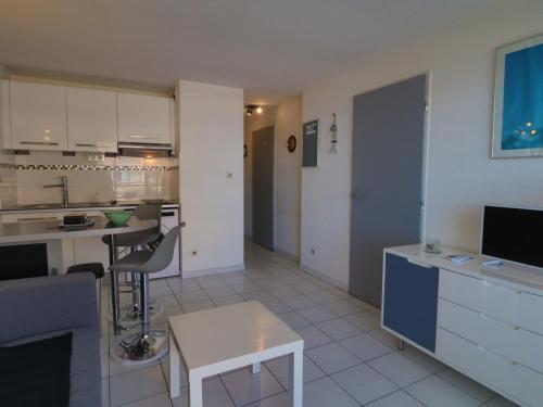 une cuisine et un salon avec une table et des chaises dans l'établissement Charmant T2 cabine rénové avec vue mer, loggia, proche plage, tout équipé - 2** - FR-1-472A-295, à Sète