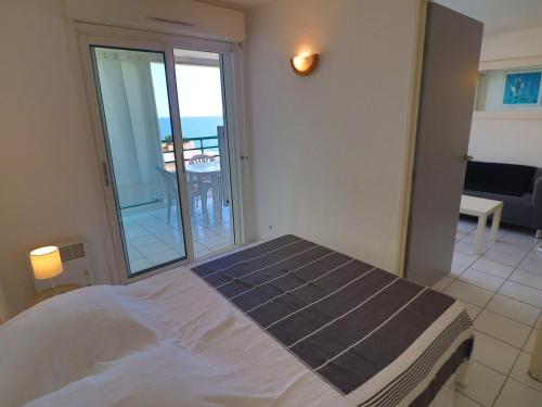 une chambre avec un lit et une vue sur l'océan dans l'établissement Charmant T2 cabine rénové avec vue mer, loggia, proche plage, tout équipé - 2** - FR-1-472A-295, à Sète