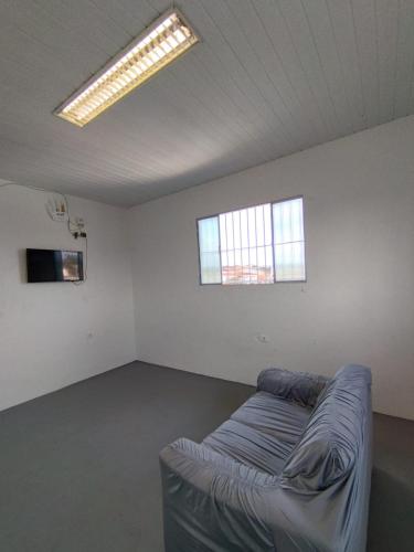 um quarto vazio com um sofá no meio em JM Alojamento em Igarassu