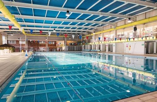a large swimming pool filled with blue water at NB166 - Porth Bay Hideaway in Newquay Bay Resort