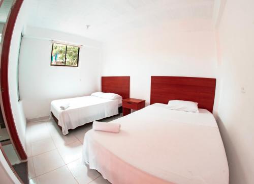 San Luis的住宿－Hostal Chez Holman，酒店客房设有两张床和窗户。