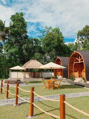 een groep gebouwen met tafels en parasols bij Besakih Homestay & Villa in Besakih