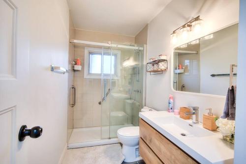 e bagno con doccia, servizi igienici e lavandino. di Style & Comforts by Montreal - New - 3BR Bungalow a Candiac