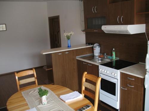 a small kitchen with a table and a stove and a sink at Apartment Planinski Rai in Tryavna