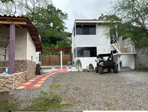 a house with a jeep parked in front of it at Departamento Amueblado con Alberca Pedregal D in Tamasopo