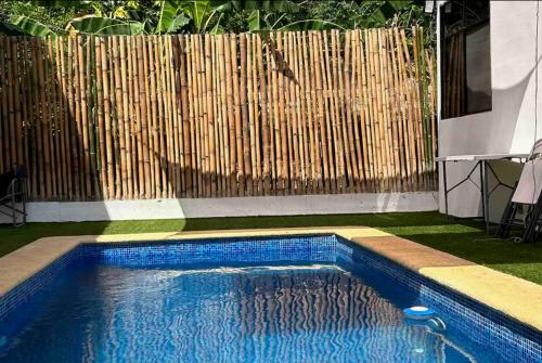 a swimming pool in front of a wooden fence at Departamento Amueblado con Alberca Pedregal D in Tamasopo