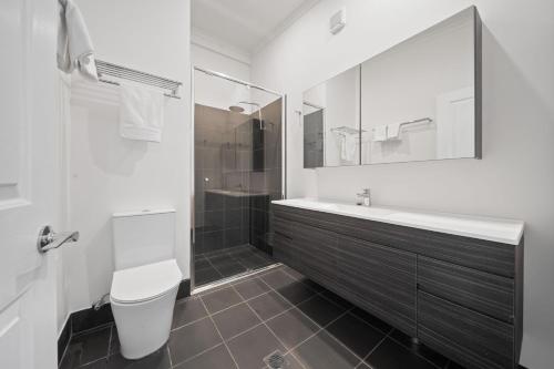 a bathroom with a sink and a toilet and a mirror at Tukidale Cottage - 3BR Cottage l WiFi l Air-Con l Relaxing Location in Crackenback