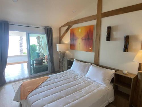 a bedroom with a large bed and a large window at Nam Jai Beach Bungalow - Tropical in Nathon Bay