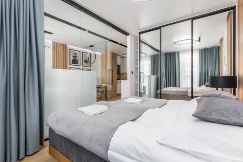 ein Schlafzimmer mit einem großen weißen Bett mit Glaswänden in der Unterkunft Apartamenty Polanowscy Baltic Marina Residence z mini SPA przy Bałtyckiej in Kołobrzeg